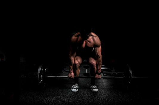 Athlete setting up a heavy deadlift in a dark gym