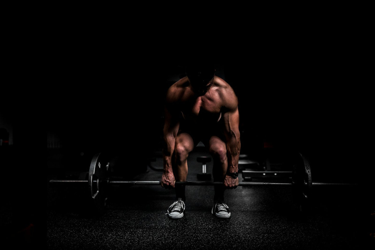 Athlete setting up a heavy deadlift in a dark gym