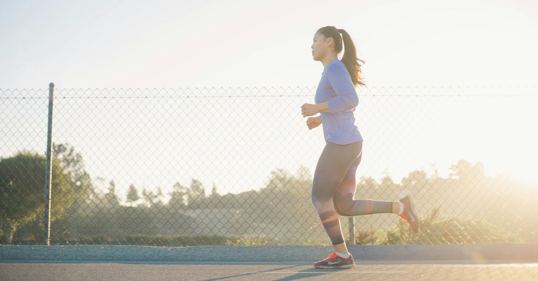 A woman jogging outdoors on a sunny day