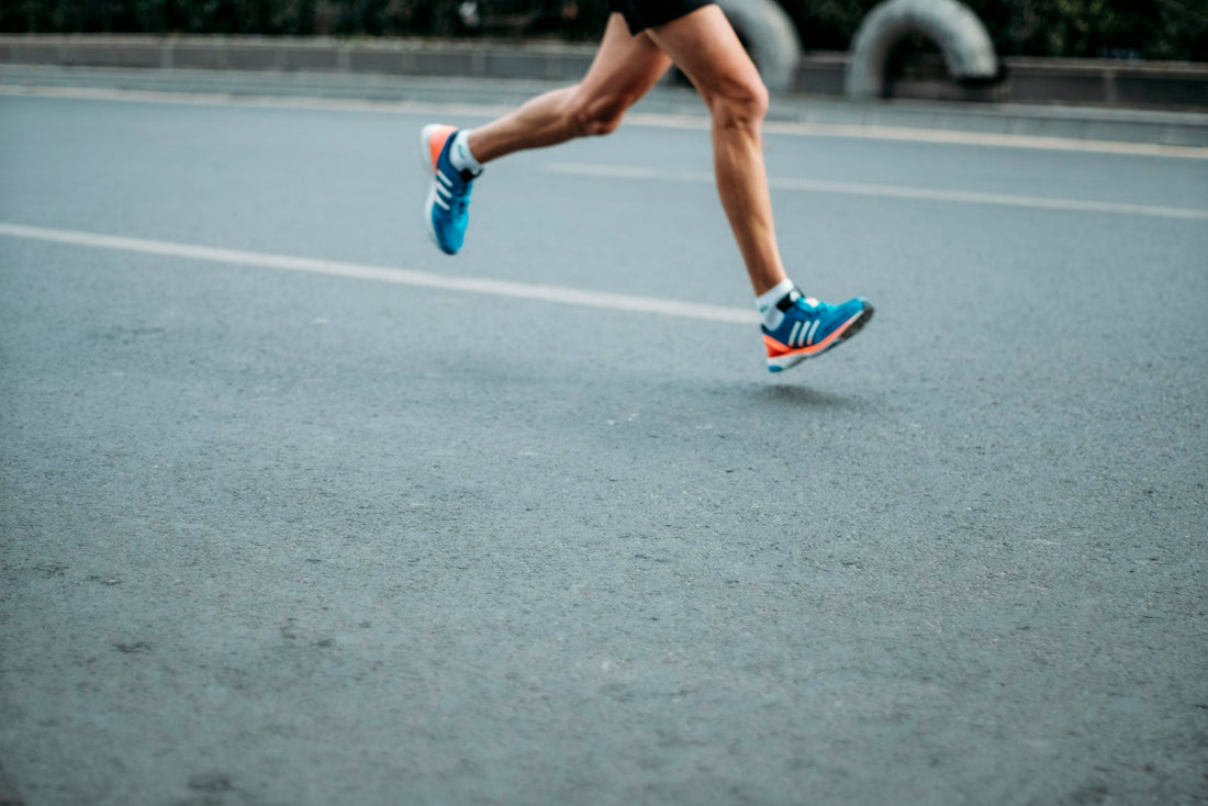 Runner's legs and trainers on the road
