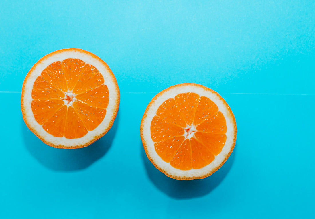 Two halves of a fresh orange on a bright blue background