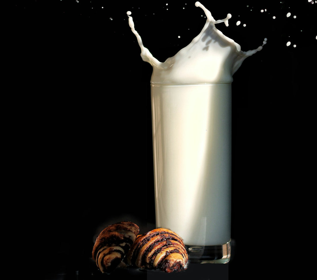 A tall glass of milk with a splash, on a dark background