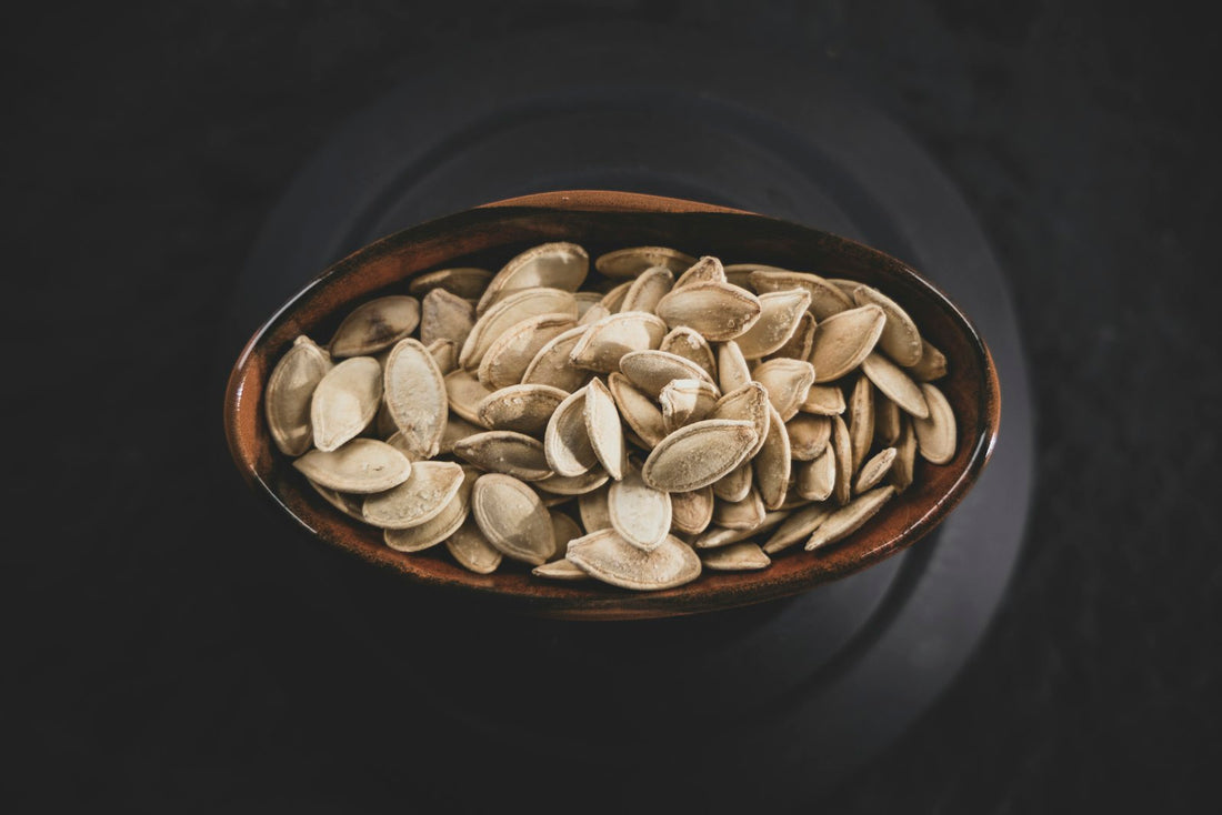 Pumpkin seeds in a wooden bowl on a dark background