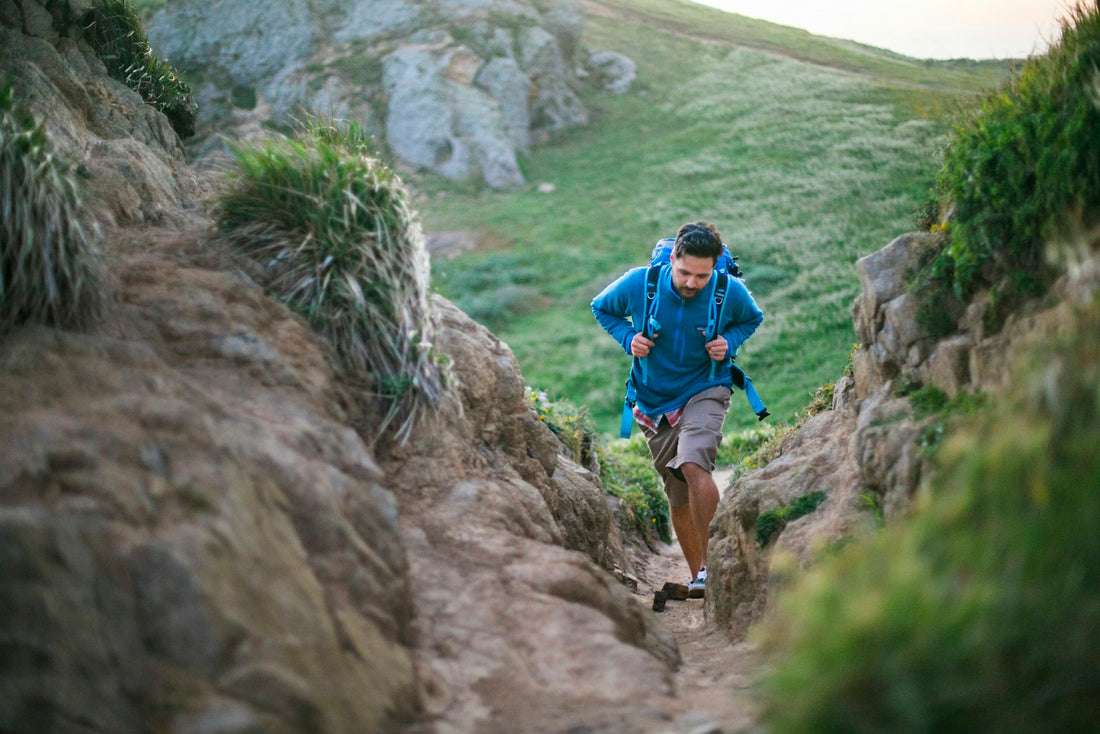 Runner climbing a steep green trail during a hard outdoor run