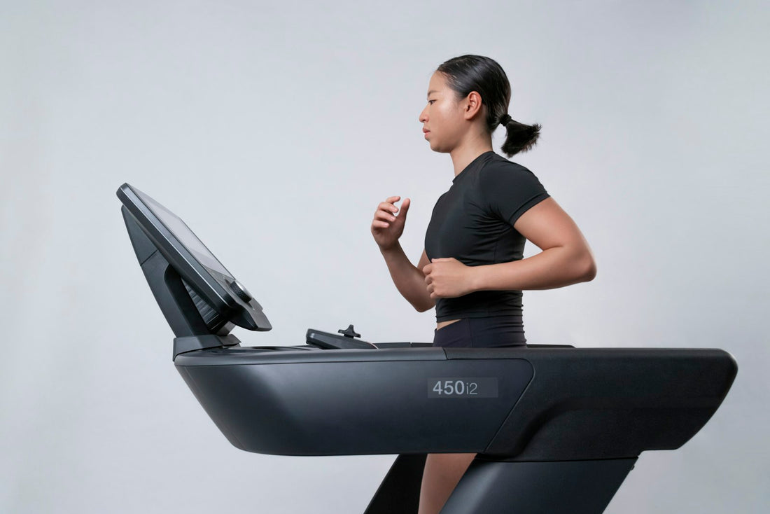 A woman running on a treadmill in a bright gym