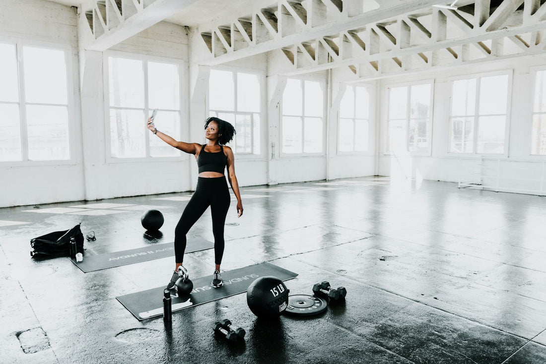 Woman in athletic wear in a bright training studio with kettlebells and weights