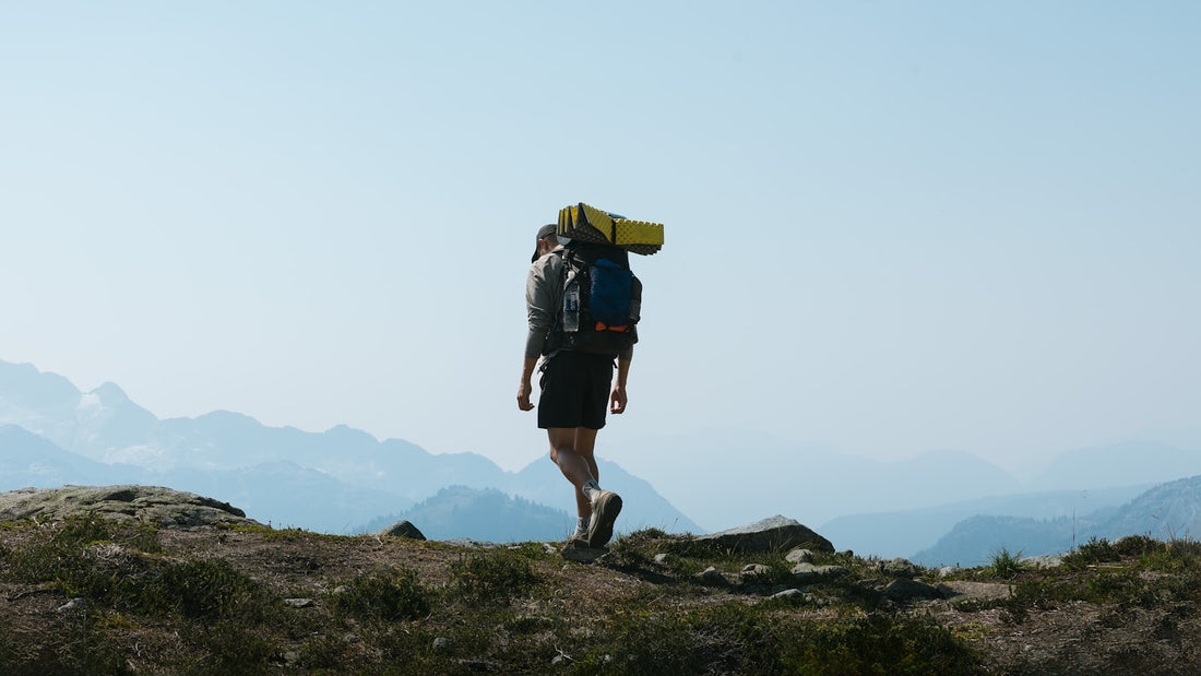 Person walking uphill carrying a loaded backpack