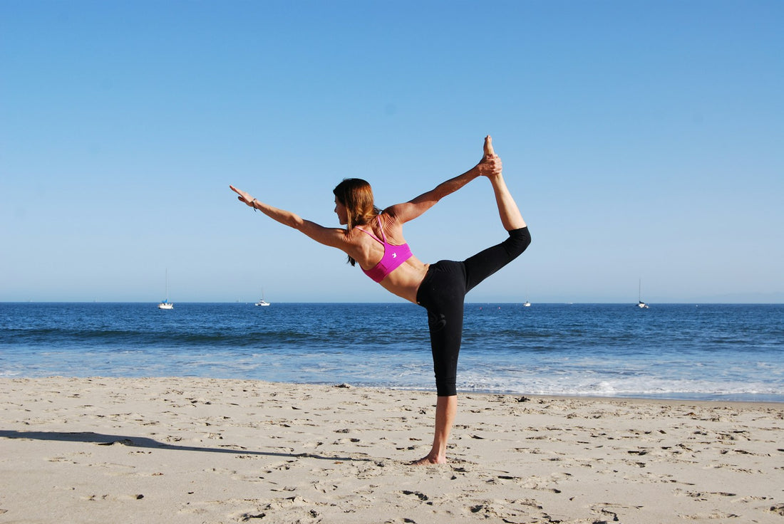 Person balancing on one leg on a bright beach