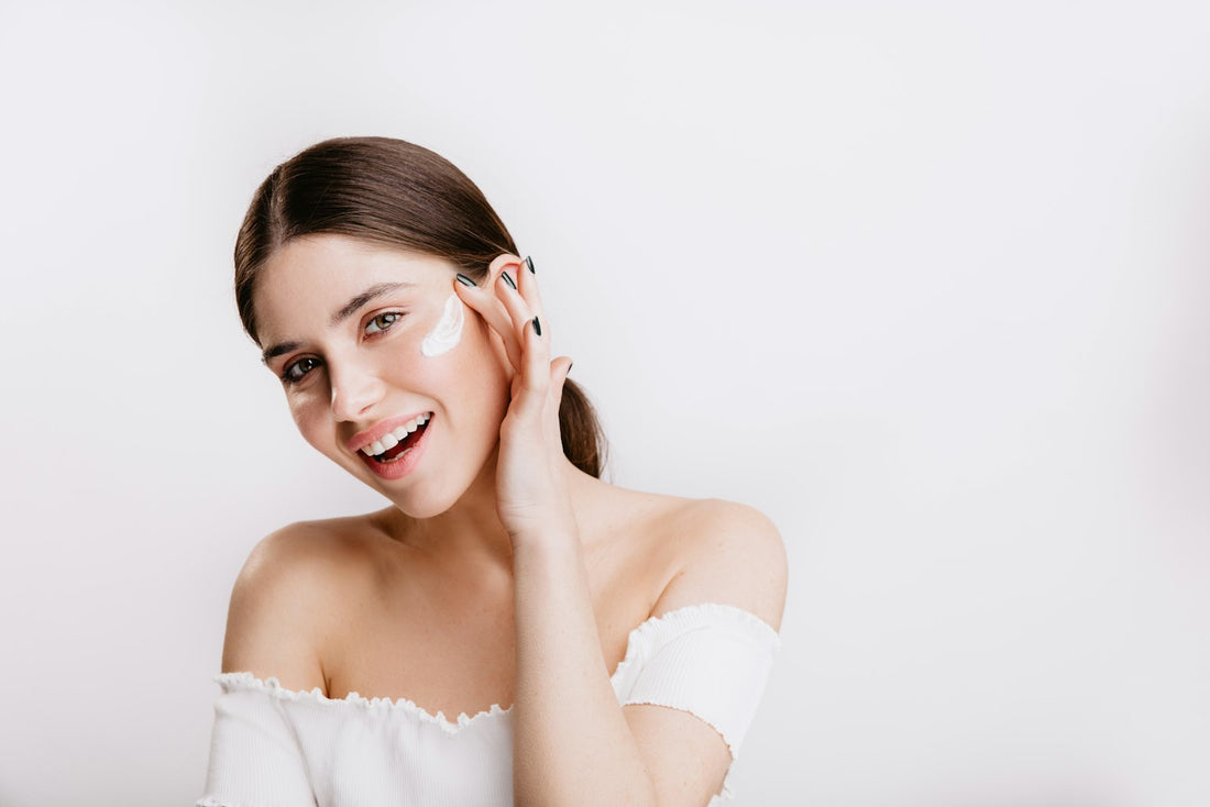 Woman with healthy glowing skin smiling and touching her face