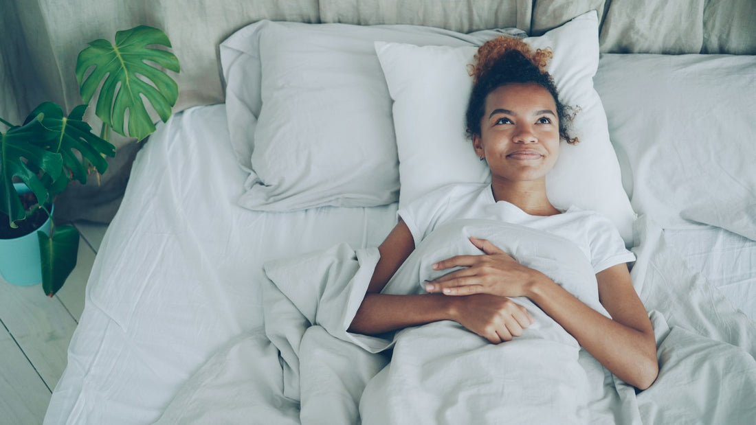 A person resting comfortably in a bright, airy bedroom