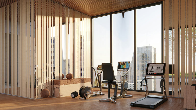 Bright modern gym studio with exercise equipment and a city view through large windows