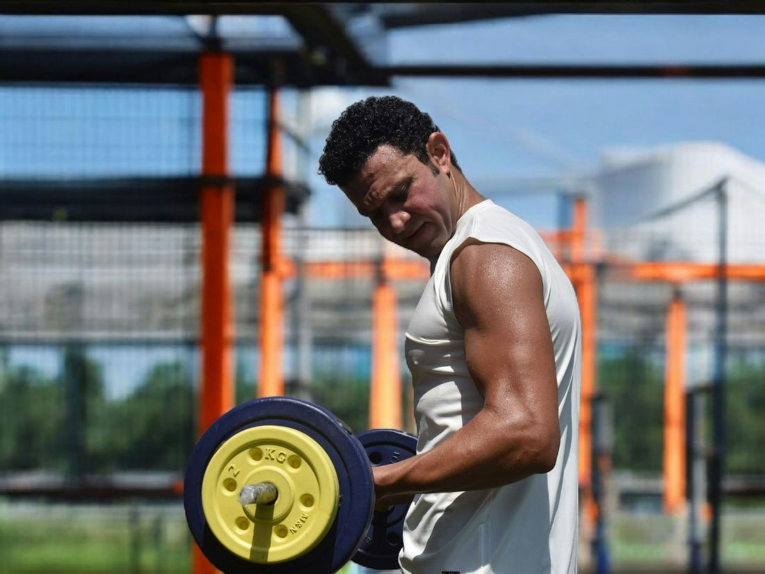 Person lifting a loaded barbell outdoors in bright daylight