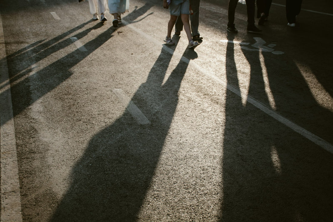 People walking with long shadows in sunlight