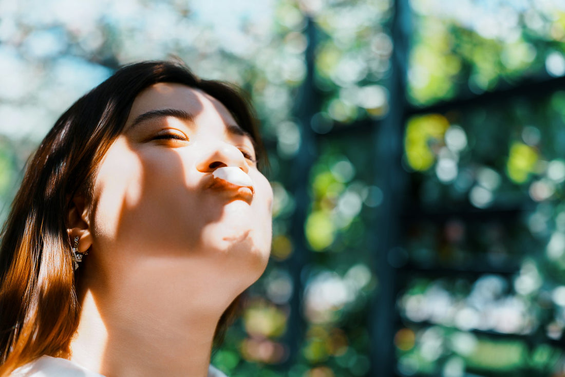 Woman breathing deeply with eyes closed in the sun
