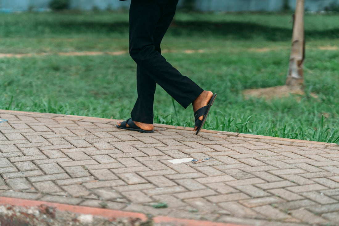 Person walking on a brick path beside grass