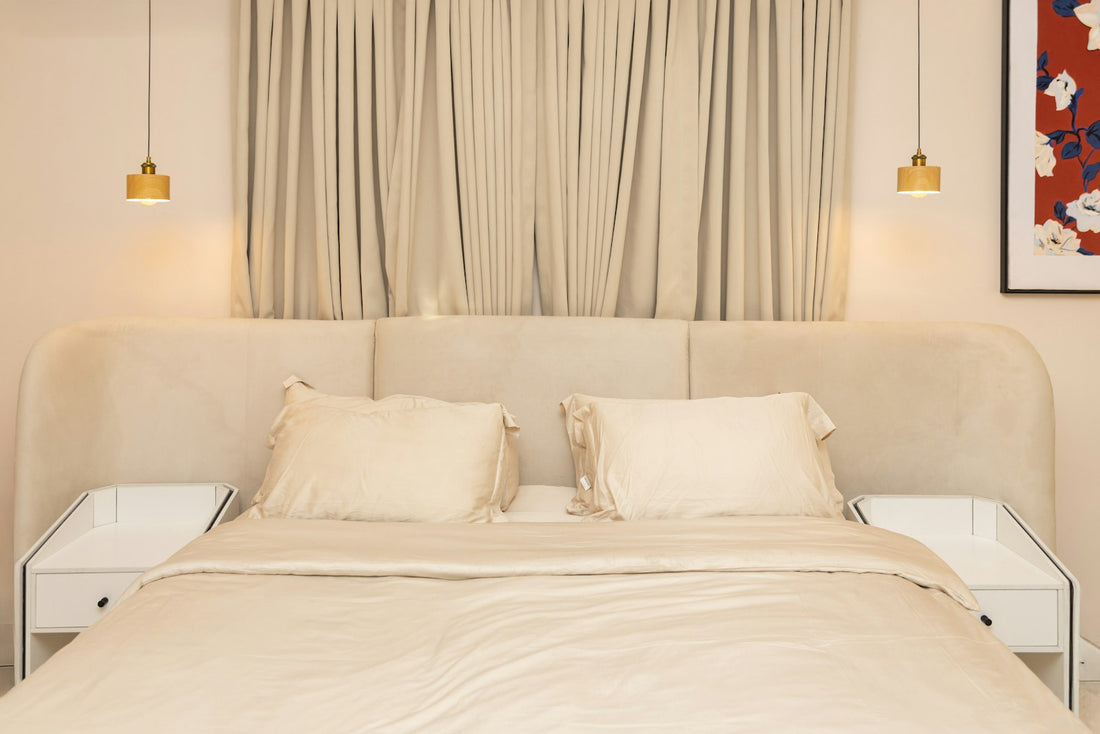 Softly lit bedroom at night with a made bed and warm bedside lighting