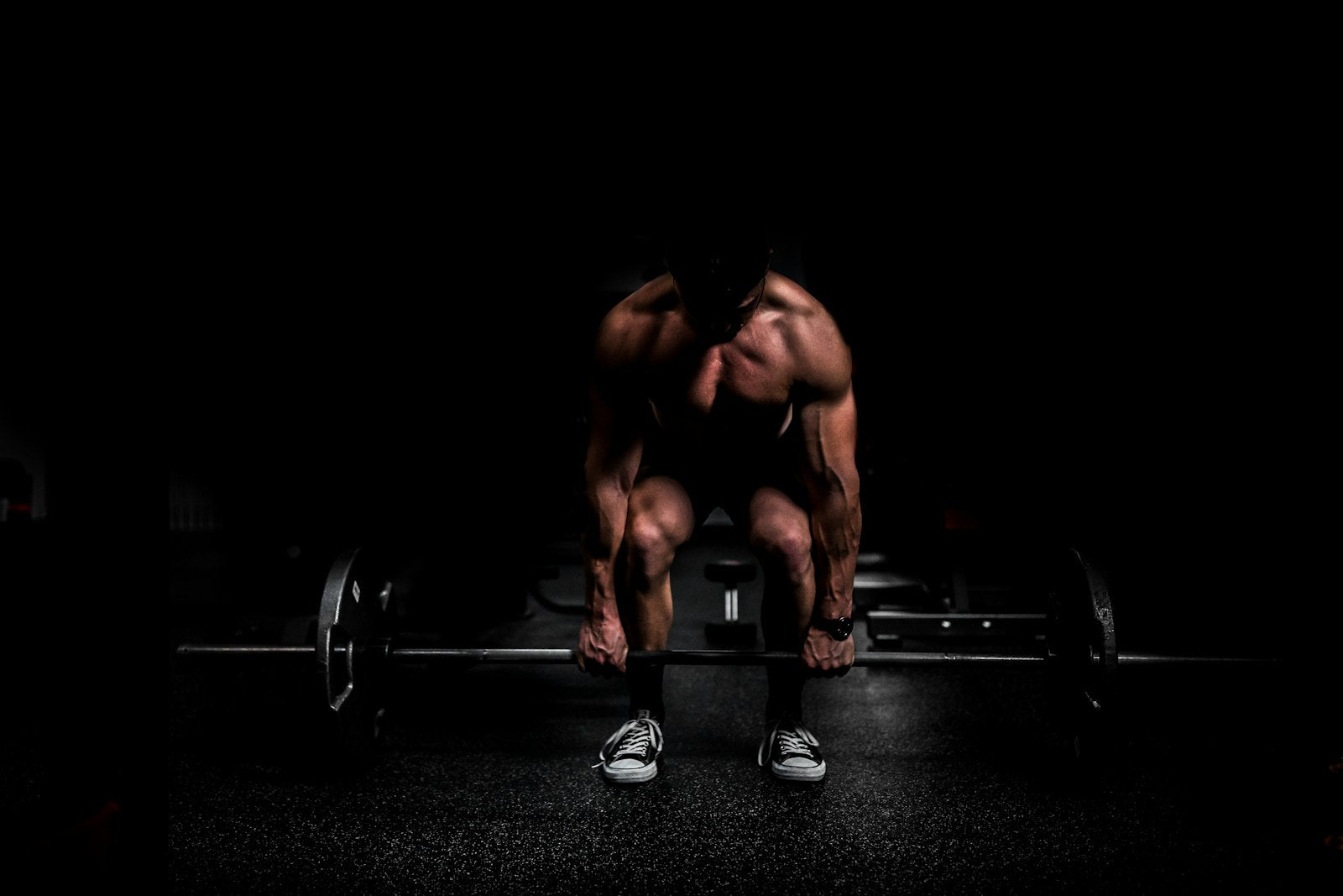 Athlete setting up a heavy deadlift in a dark gym