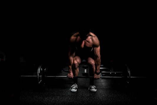 Athlete setting up a heavy deadlift in a dark gym